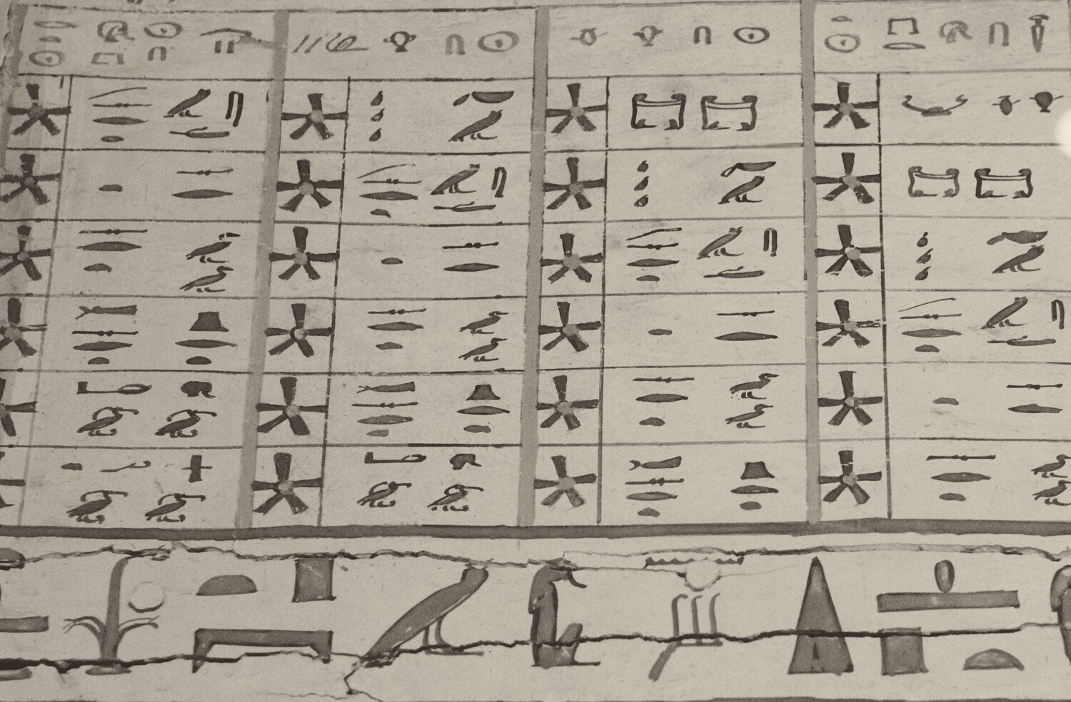 Close view of a painted grid of hieroglyphs: a row of labels along the top, then rows of boxes, each pairing a five-pointed star with a group of signs; a band of larger hieroglyphs runs underneath.